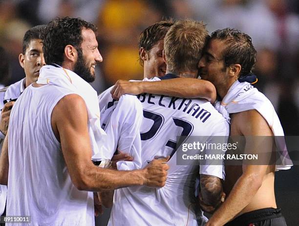David Beckham of the Los Angeles Galaxy is hugged by former teammates Giusepe Favalli , Luca Antonini and Mathieu Flamini of AC Milan after their...
