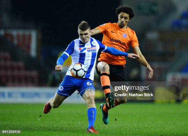 Lewis Montrose of AFC Fylde and Max Power of Wigan Athletic in action during The Emirates FA Cup Second Round Replay match between Wigan Athletic and...