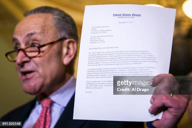 Senate Minority Leader Charles Schumer holds a letter written to Senate Majority Leader Mitch McConnell and House Speaker Paul Ryan , expressing...
