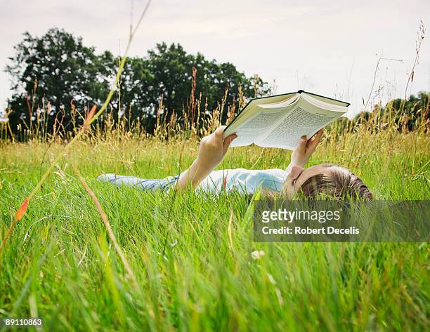 girl lying down reading. - fille lire gazon photos et images de collection