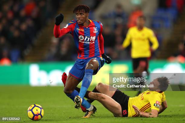 Wilfried Zaha of Crystal Palace is tackled by Tom Cleverley of Watford during the Premier League match between Crystal Palace and Watford at Selhurst...