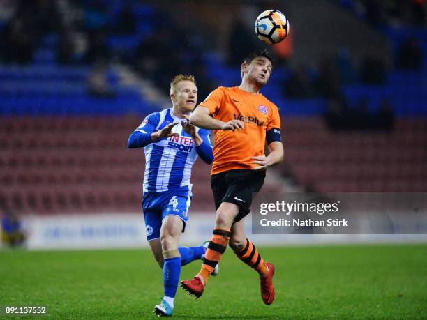 Sam Finley of AFC Fylde and David Perkins of Wigan Athletic in action during The Emirates FA Cup Second Round Replay match between Wigan Athletic and...