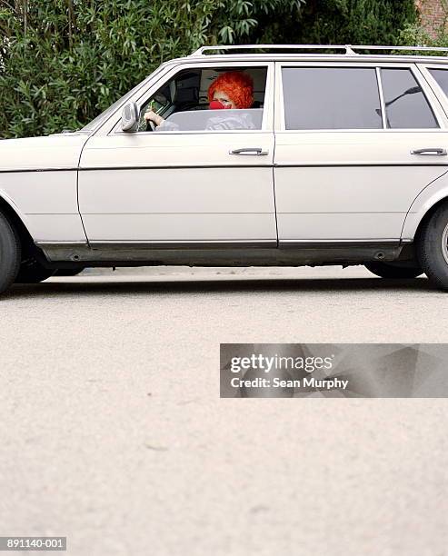 clown driving white car, side view - funny clown stockfoto's en -beelden