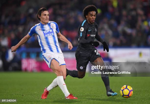 Dean Whitehead of Huddersfield Town passes the ball under pressure from Willian of Chelsea during the Premier League match between Huddersfield Town...