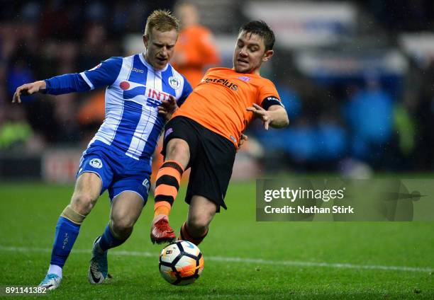 Sam Finley of AFC Fylde and David Perkins of Wigan Athletic in action during The Emirates FA Cup Second Round Replay match between Wigan Athletic and...