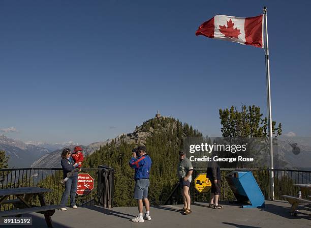 Sightseers atop the Sulphur Mountain tramway lookout take pictures as seen in this 2009 Banff Springs, Canada, early morning landscape photo.