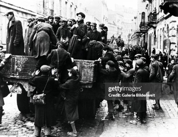 Jewish men are transported from the Warsaw Ghetto by Wehrmacht soldiers, to work on sites elsewhere, Poland, 1941.