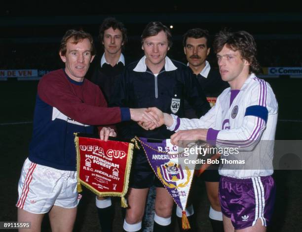 Nottingham Forest captain Ian Bowyer and Anderlecht's Frank Vercauteren exchange pennants watched by Referee Horst Brummeier and his linesmen prior...
