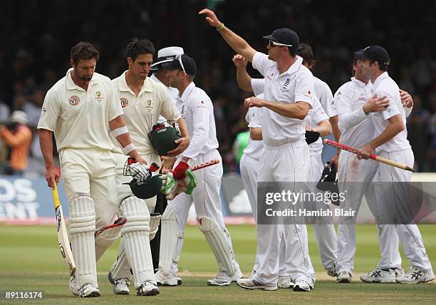 Ben Hilfenhaus and Mitchell Johnson of Australia walk off as England players celebrate victory during day five of the npower 2nd Ashes Test Match...