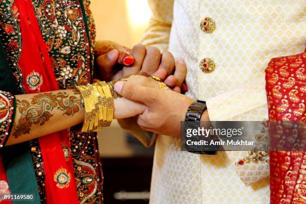 holding hands - pakistani gold jewelry 個照片及圖片檔