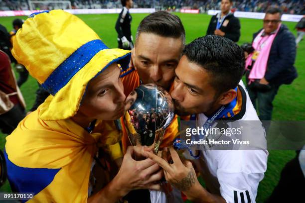 Jose Torres, Juninho and Javier Aquino of Tigres kiss the trophy to celebrate after winning the second leg of the Torneo Apertura 2017 Liga MX final...