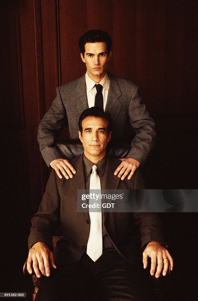 Two business men in conference room, young man standing