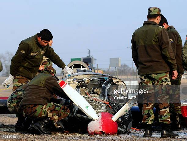 Technicians of the Chilean Air Force inspect the wreckage of an airplane that fall in Santiago's Fish Market, during a training flight on July 20,...