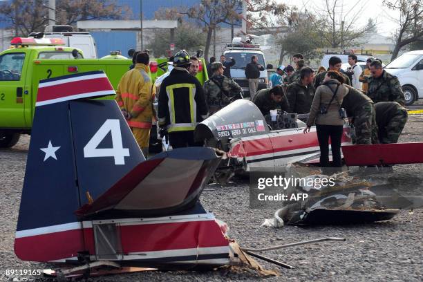 Firefighters and technicians of the Chilean Air Force inspect the wreckage of an airplane that fall in Santiago's Fish Market, during a training...