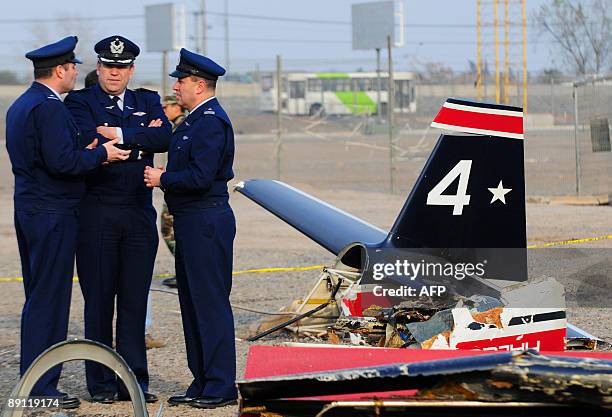 Officers of the Chilean Air Force stand next to the wreckage of an airplane that fall in Santiago's Fish Market, during a training flight on July 20,...