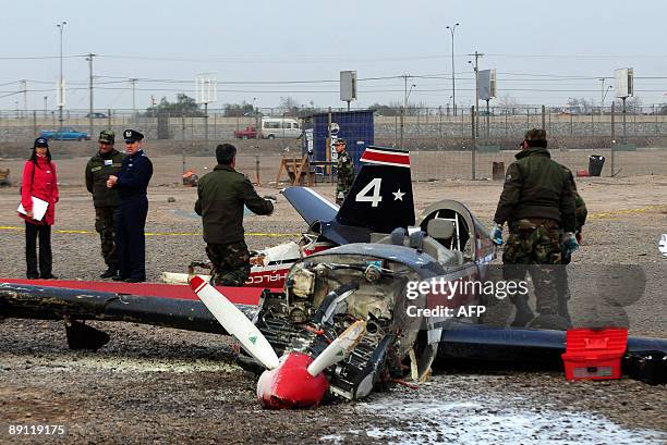 Officers and technicians of the Chilean Air Force inspect the wreckage of an airplane that fall in Santiago's Fish Market, during a training flight...