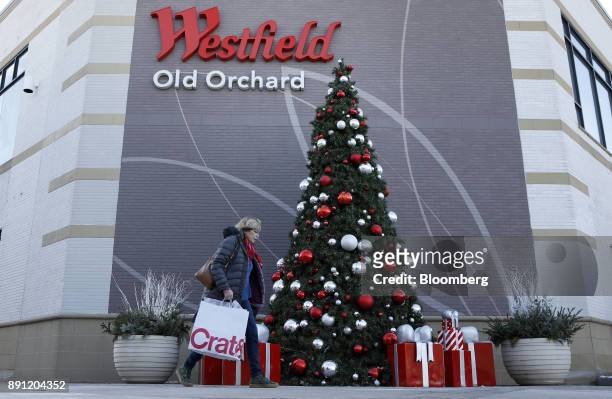 Shopper carries a Crate & Barrel bag while walking past the Westfield Mall Old Orchard in Skokie, Illinois, U.S., on Tuesday, Dec. 12, 2017....
