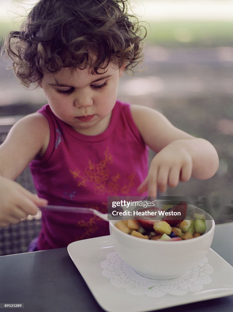 Girl eating fruit salad