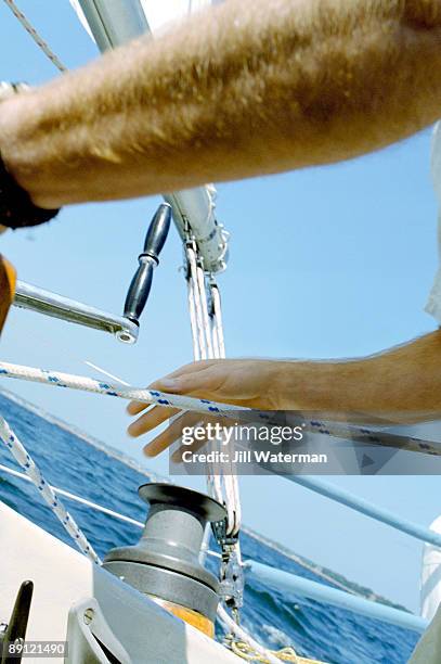 man grasping mainsail line - sailor arm stockfoto's en -beelden