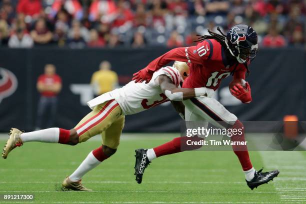 DeAndre Hopkins of the Houston Texans is tackled by Dontae Johnson of the San Francisco 49ers in the first quarter at NRG Stadium on December 10,...