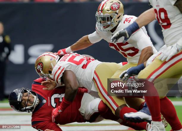 Tom Savage of the Houston Texans is hit by Elvis Dumervil of the San Francisco 49ers in the second quarter at NRG Stadium on December 10, 2017 in...