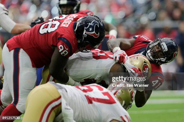 Carlos Hyde of the San Francisco 49ers is tackled by Zach Cunningham of the Houston Texans and D.J. Reader in the second half at NRG Stadium on...