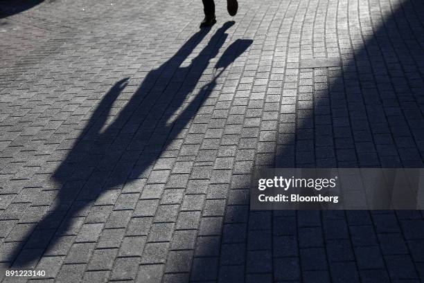 The shadow of a shopper is seen carrying a bag at the Westfield Mall Old Orchard in Skokie, Illinois, U.S., on Tuesday, Dec. 12, 2017....