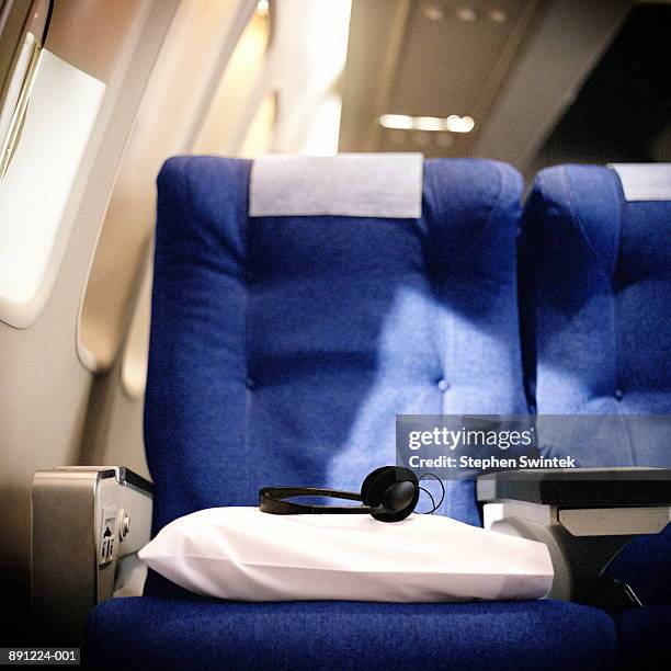 pillow and headphones on seat in airliner - vehicle seat foto e immagini stock