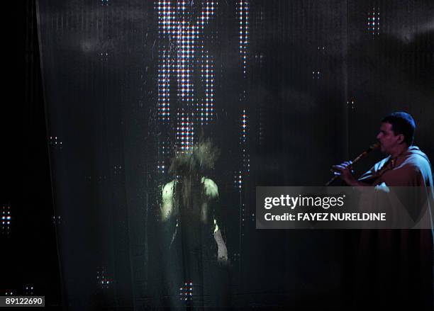 An African artist performs before an an Algerian Musician during the official closing ceremony of the 2nd Pan-African Cultural Festival , on July 20,...