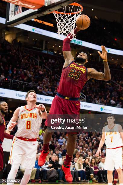 LeBron James of the Cleveland Cavaliers dunks over Luke Babbitt of the Atlanta Hawks during the first half at Quicken Loans Arena on December 12,...