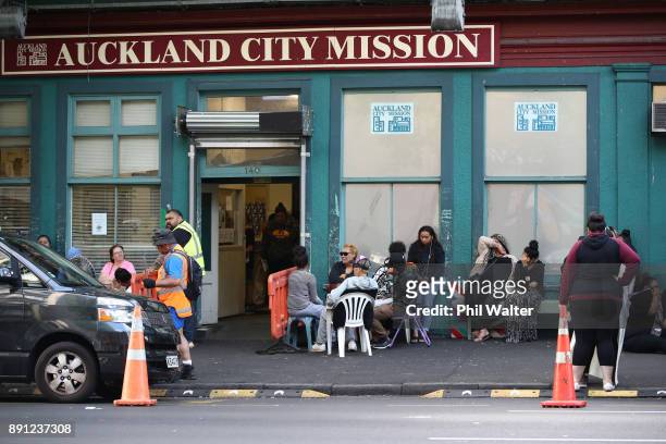 People wait on the street outside Auckland City Mission as they await donations of food and Christmas presents for their families over Christmas on...