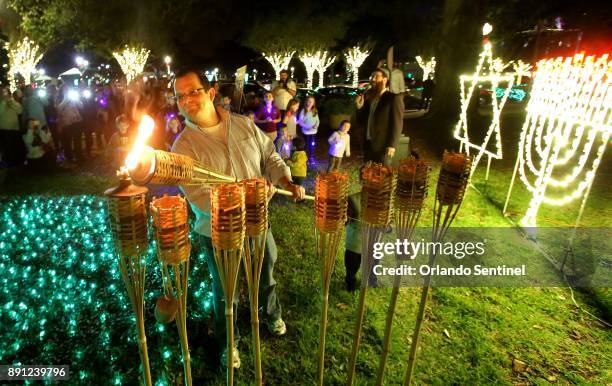 Adam Rashkind of Winter Garden, Fla. Symbolically lights the first candle of the eight days of Hannukah as members of the central Florida Jewish...