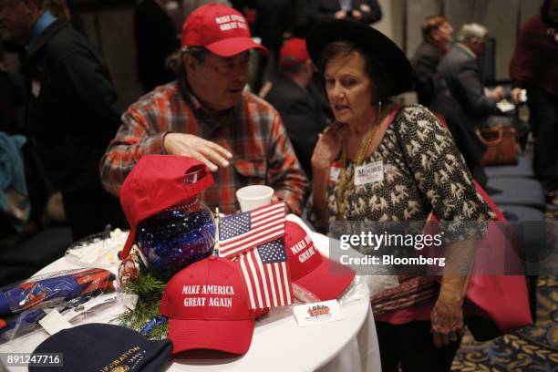 Attendees mingle as American flags and "Make America Great Again" hats are displayed on a table during an election night party for Roy Moore,...