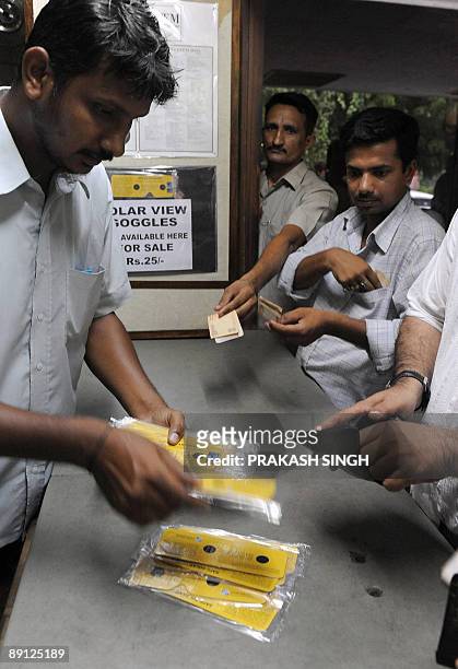 Indian customers queue to buy solar viewing goggles at The Nehru Planetarium in New Delhi on July 21, 2009. I ndia will witness a major celestial...