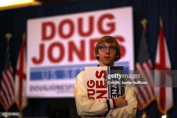 Supporter of democratic U.S. Senatorial candidate Doug Jones holds a sign as he watches election returns during an election night gathering the...