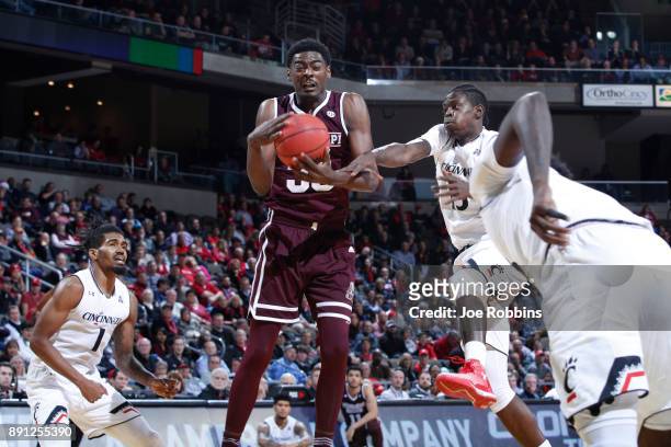 Aric Holman of the Mississippi State Bulldogs rebounds against Tre Scott and Jacob Evans of the Cincinnati Bearcats in the second half of a game at...