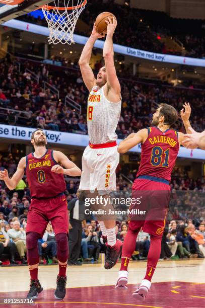 Luke Babbitt of the Atlanta Hawks dunks over Kevin Love and Jose Calderon of the Cleveland Cavaliers during the second half at Quicken Loans Arena on...