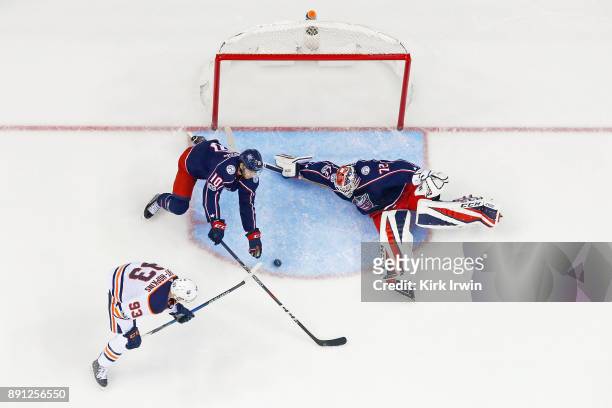 Sergei Bobrovsky of the Columbus Blue Jackets stops a shot from Ryan Nugent-Hopkins of the Edmonton Oilers as Alexander Wennberg of the Columbus Blue...