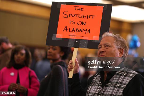 Supporter of Democratic U.S. Senatorial candidate Doug Jones holds a sign as he watches election returns during an election night gathering the...