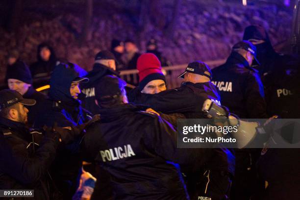 Policemen detain protester during blockade of Polish parliament organized by opposition group Obywatele RP in Warsaw on December 12, 2017.