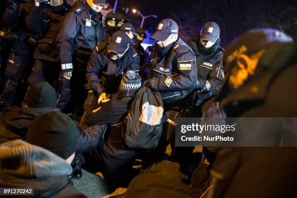 Policemen detain protester during blockade of Polish parliament organized by opposition group Obywatele RP in Warsaw on December 12, 2017.