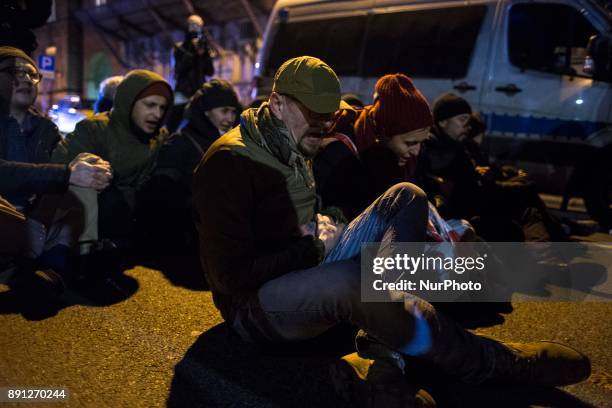 Protesters sit on the street during blockade of Polish parliament organized by opposition group Obywatele RP in Warsaw on December 12, 2017.