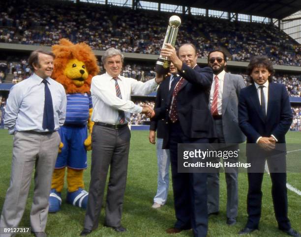 Chelsea FC Manager John Neal accompanied by Assistant Manager Ian McNeill and Chelsea player Mickey Thomas is presented with the 1983-84 Canon League...