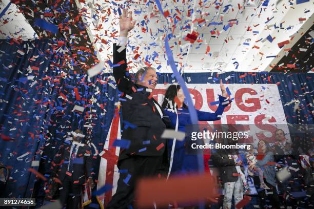 Confetti falls as Senator-elect Doug Jones, a Democrat from Alabama, left, and wife Louise Jones wave to the audience at an election night party in...