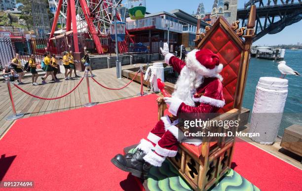 Santa Claus waves to school children in the hot summer sunshine at Luna Park on December 13, 2017 in Sydney, Australia. Luna Park has pulled some...