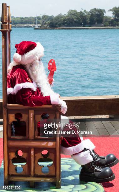 Santa Claus uses a water spray fan to keep cool in the hot summer sunshine at Luna Park on December 13, 2017 in Sydney, Australia. Luna Park has...