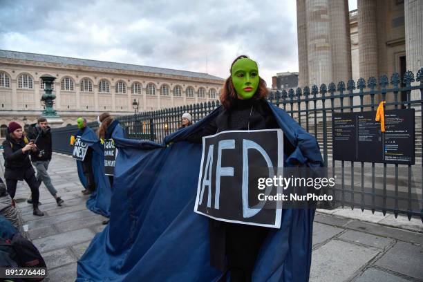 Masked protester wears a sign as climate activists put on a demonstration at the Place du Pantheon in Paris, France on December 12 the opening day of...