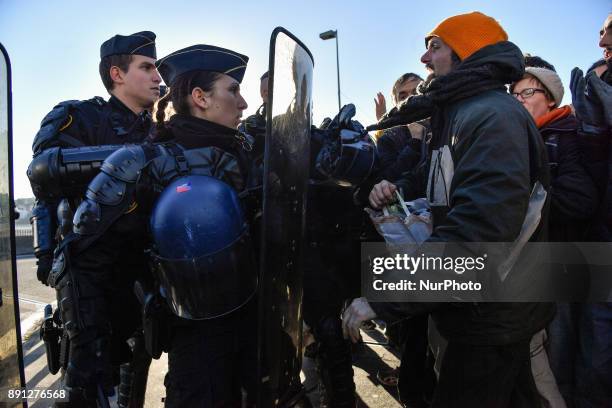 Climate activists clash with riot police officers during a protest in Paris on December 12, 2017 as French President Emmanuel Macron hosts One Planet...