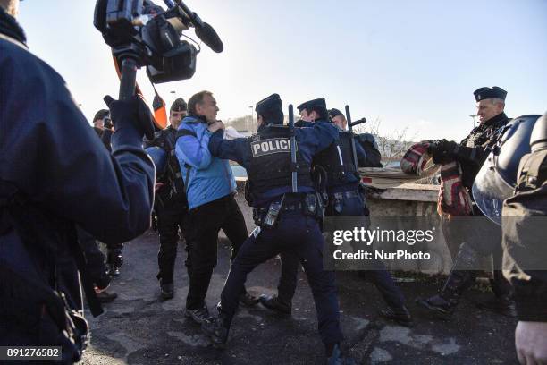 Climate activists clash with riot police officers during a protest in Paris on December 12, 2017 as French President Emmanuel Macron hosts One Planet...