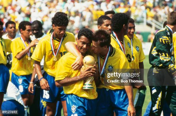 Team captain Dunga puts his arm around Romario, who is holding the FIFA World Cup Trophy, after Brazil beat Italy 3-2 on penalties in the final of...
